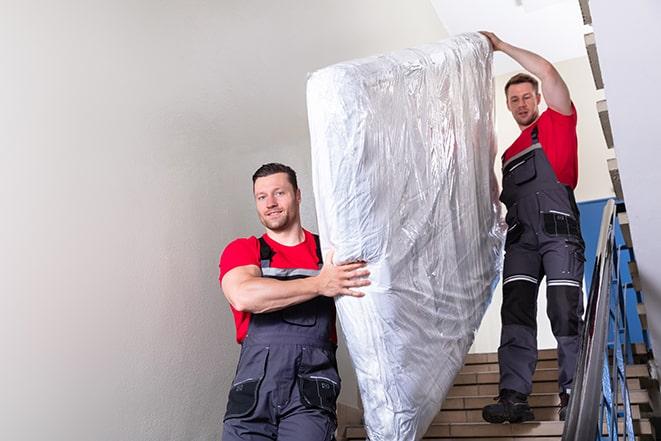 two workers lifting a box spring out of a bedroom in New Washington OH